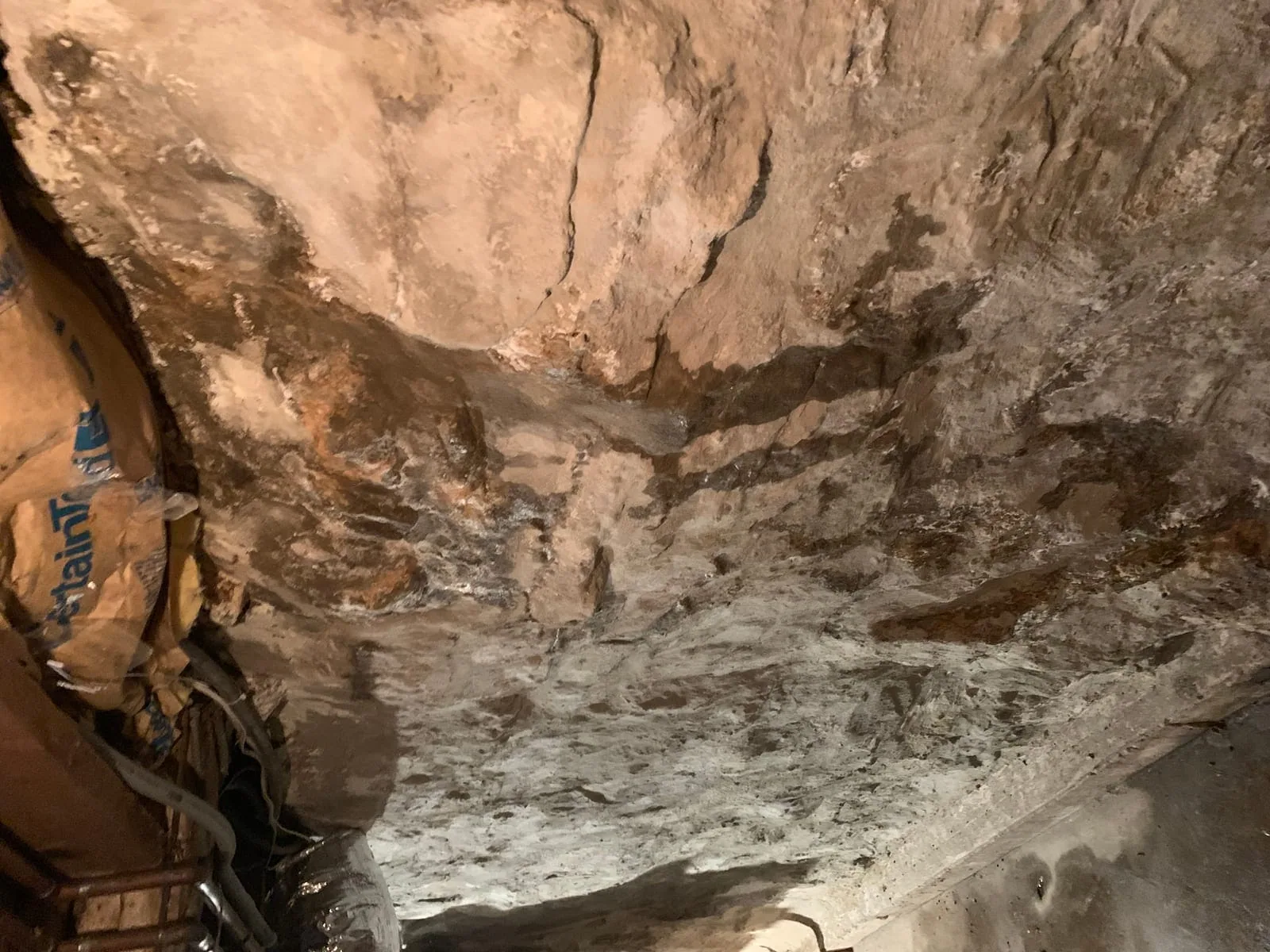 Foundation stone wall with extensive water damage and leaks in basement
