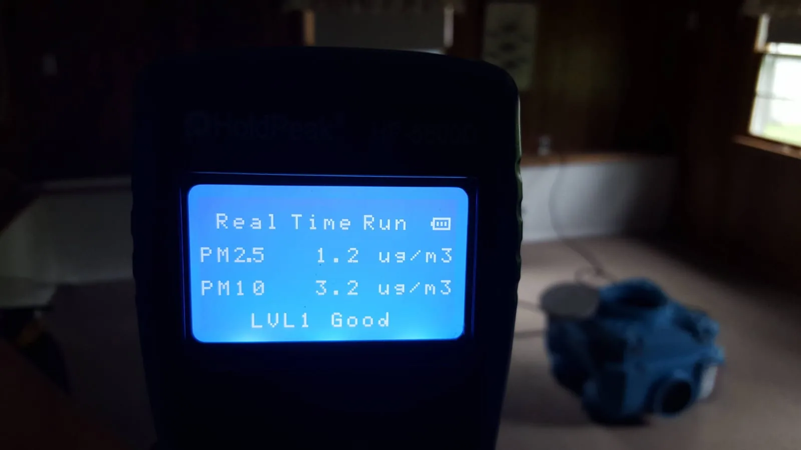 HoldPeak PM2.5 / PM10 air quality meter showing LVL1 Good reading after post-fire HVAC decontamination