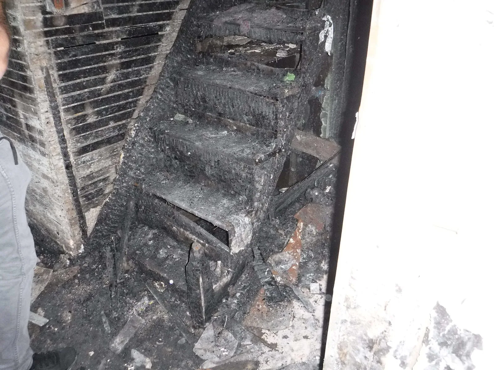 Charred basement staircase after a house fire requiring full IICRC S700 fire and smoke restoration