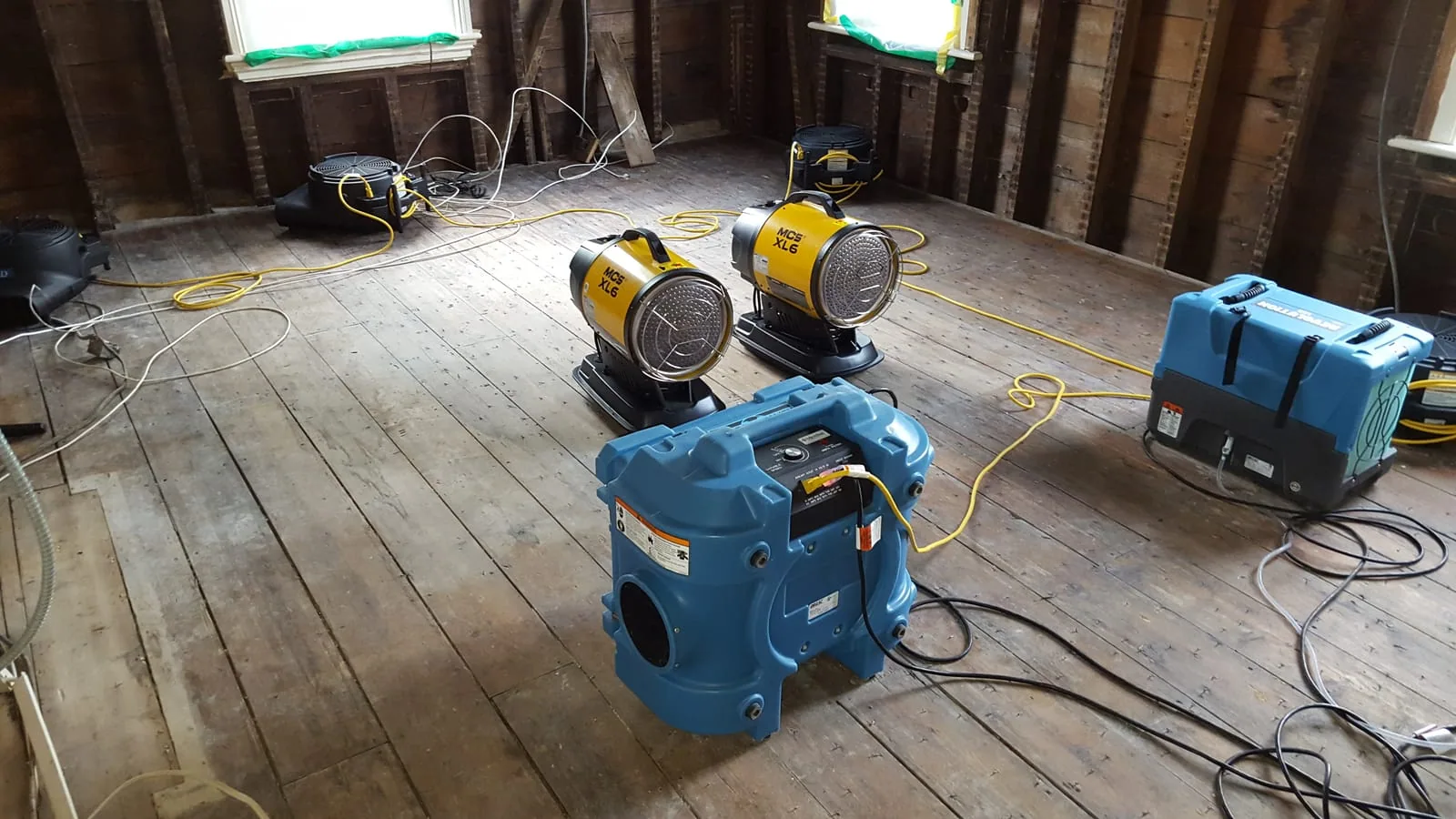 Industrial air movers and dehumidifiers set up to dry a water-damaged Connecticut home