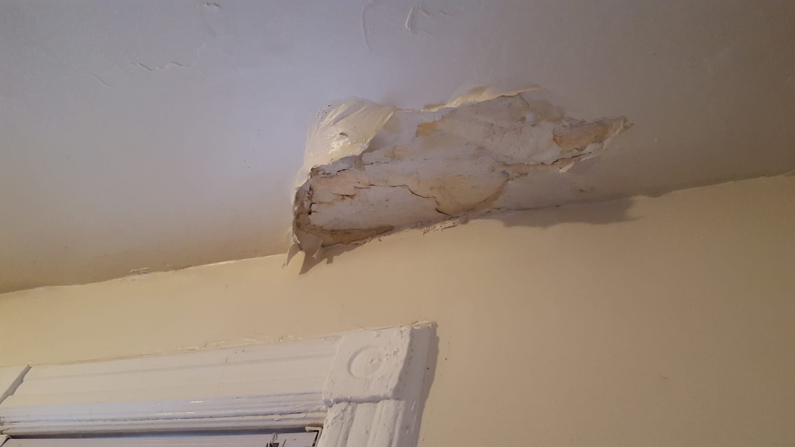 Brown water stain spreading across drywall ceiling from an active leak above